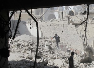 Un miembro del equipo de defensa civil de Alepo busca sobrevivientes tras el ataque aéreo con una bomba de barril en la ciudad siria en agosto de 2014. Crédito: Shelly Kittleson/IPS.