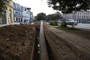 Una tubería de polietileno de alta densidad se ubica para su soterrado en una céntrica calle donde trabajadores de la empresa Aguas de La Habana modernizan las redes hidráulicas para el abastecimiento de agua potable en el municipio de Centro Habana, en la capital de Cuba. Foto: Jorge Luis Baños/IPS